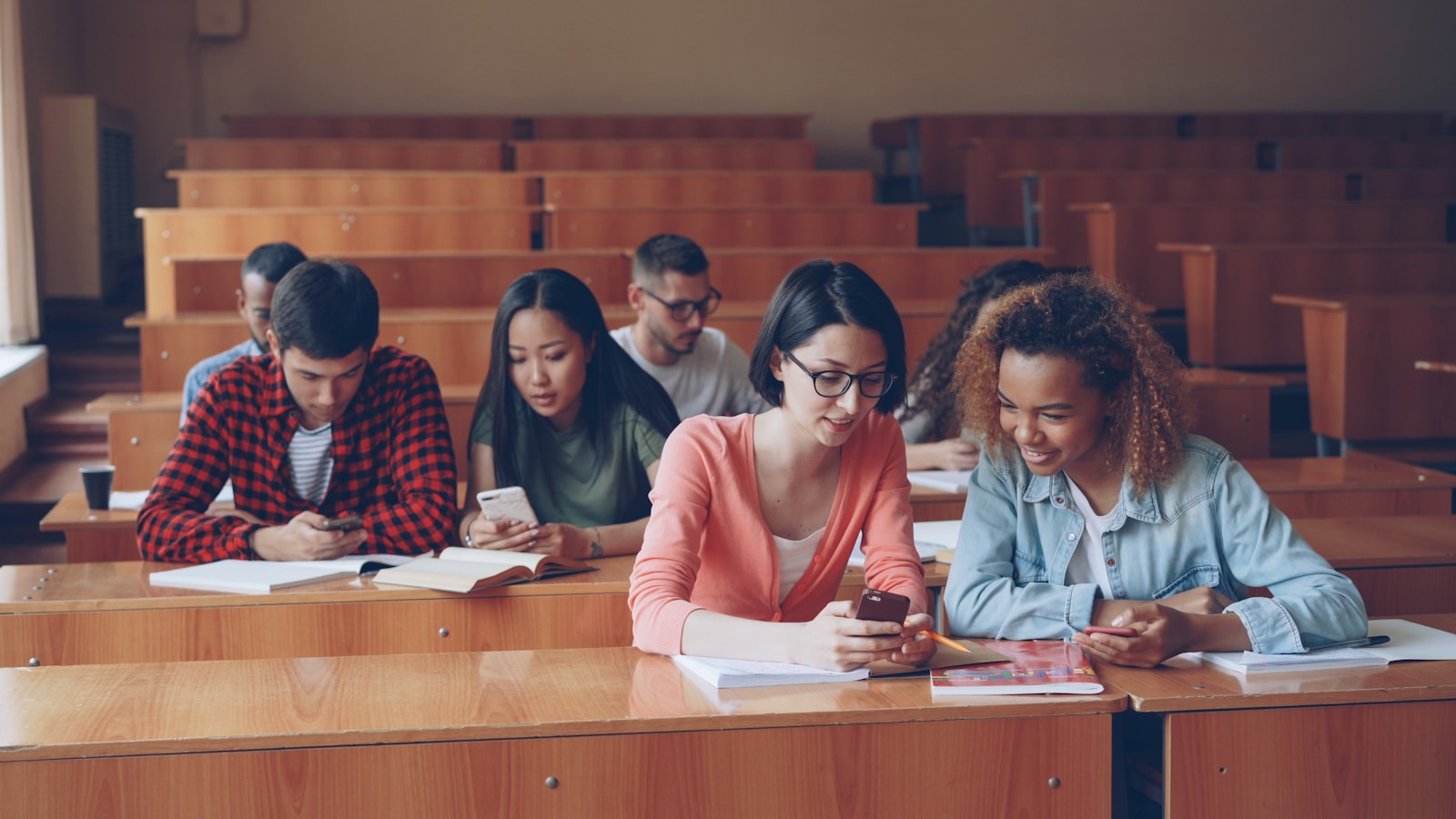 Students using phones in a lecture hall.